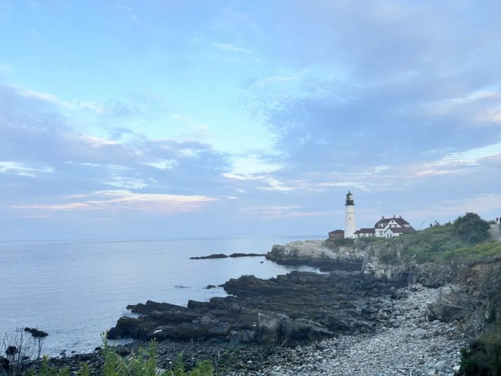 Lighthouse on a rocky coast at dusk
