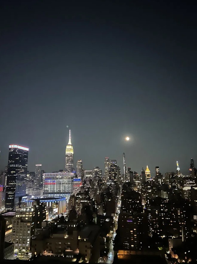 Manhattan skyline at night with a full moon